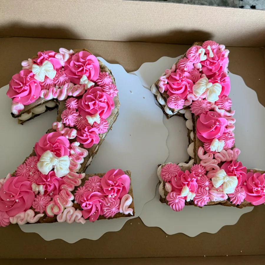 Number twenty-one cookie cake piped in pink and white buttercream