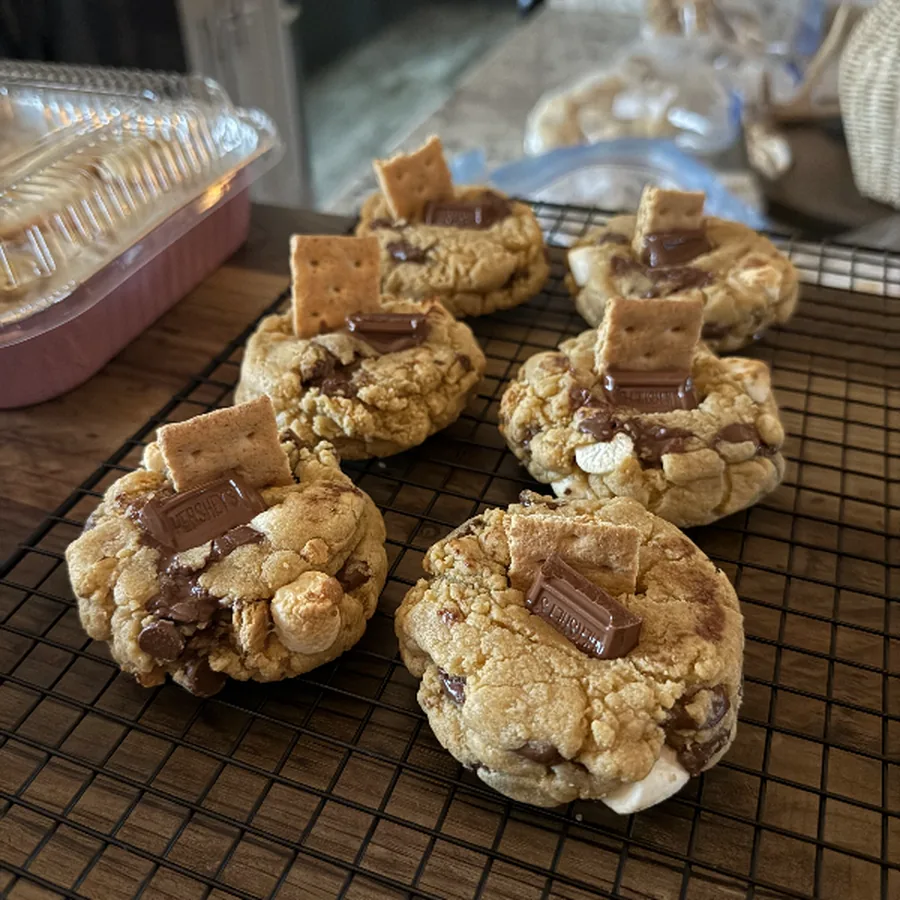 Cooling rack of thick cookies topped with chunks of chocolate bar