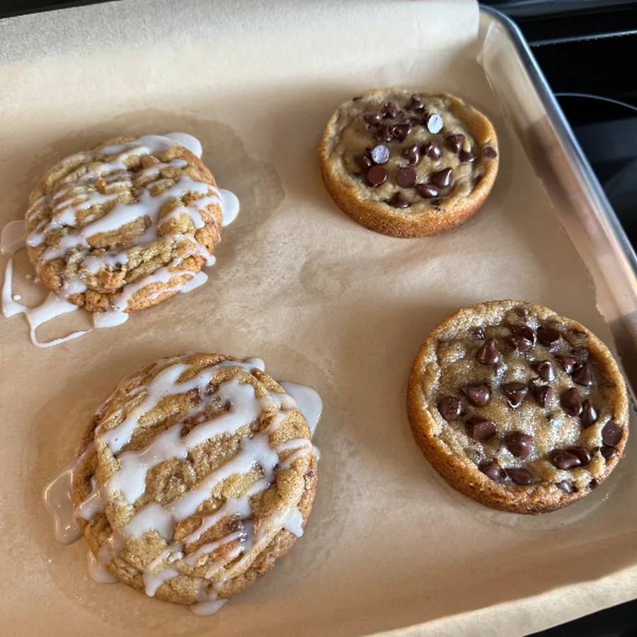 Tray of mini cookie cups drizzled with icing and studded with chocolate chips