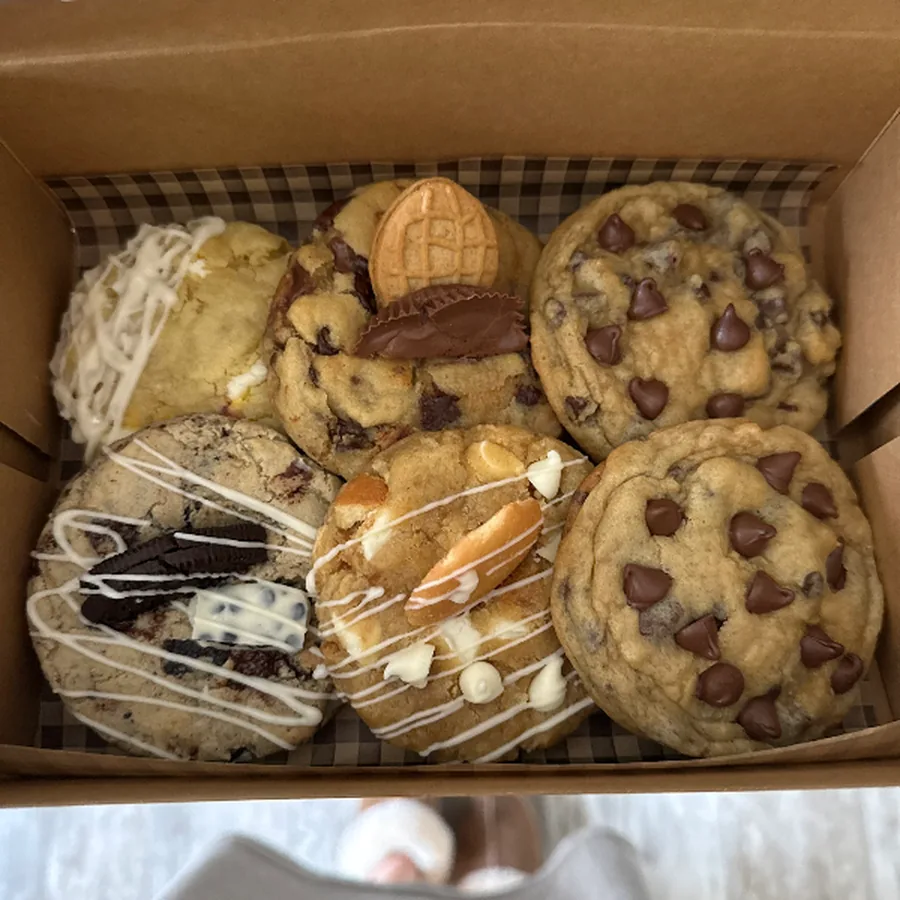 Bakery box filled with an assortment of decorated gourmet cookies